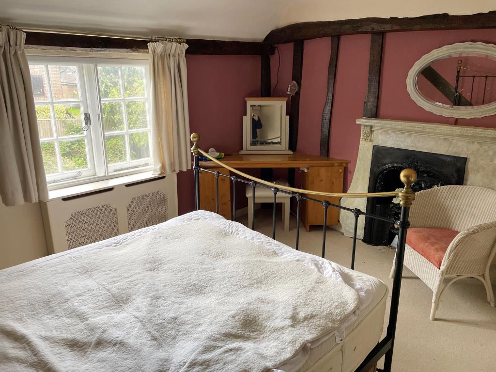 Lot: 10 - CHARACTER COTTAGE WITH GARAGE AND GARDENS - view of main bedroom with fireplace and beams